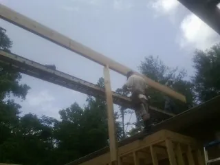 Carpenter setting a ridge beam over a new addition frame — Ice Dam Removal by Roofing Brothers in Ecorse