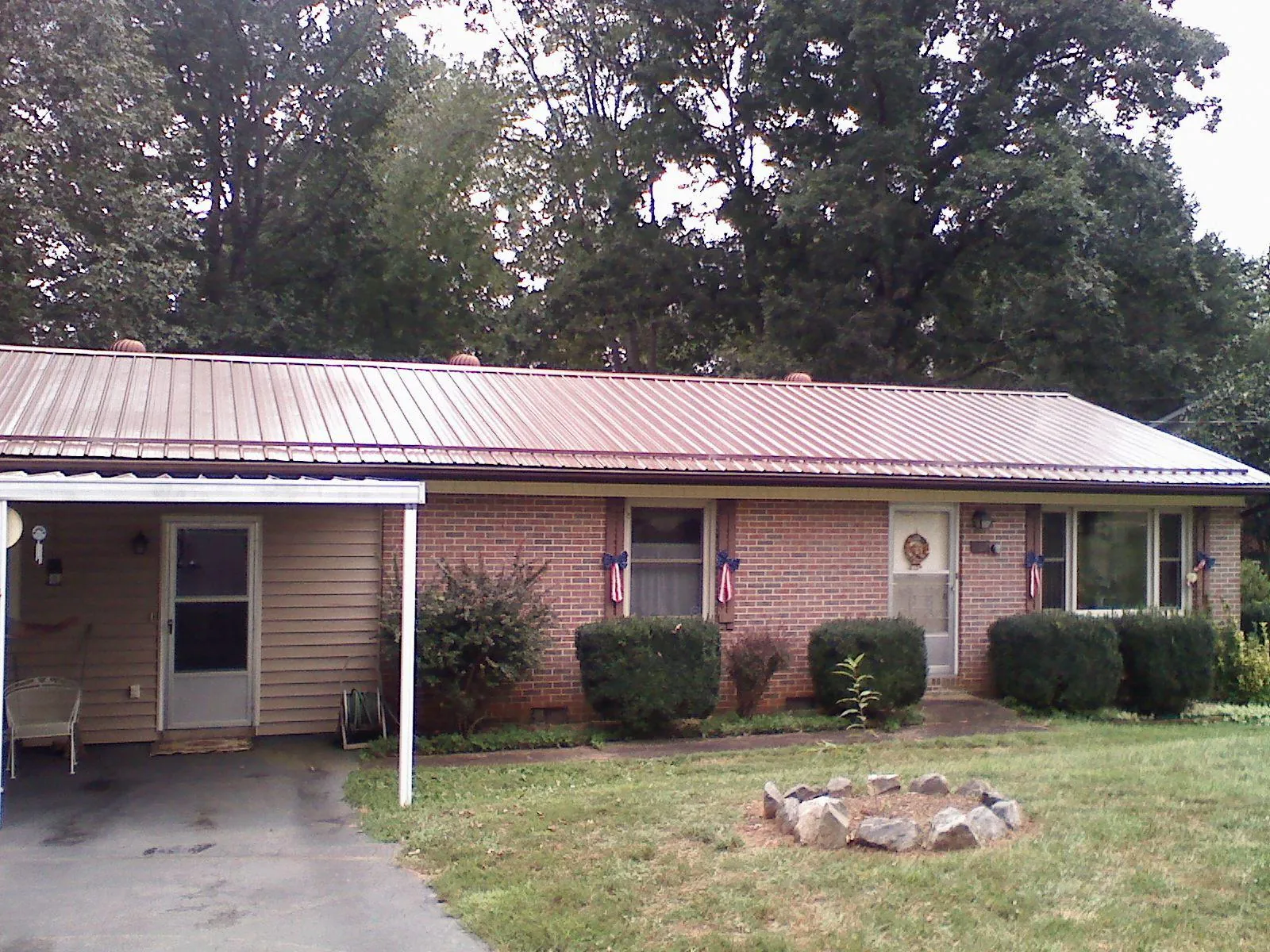 Bronze metal roof and carport on a brick ranch home — Roof Repair work by our crew in Ecorse